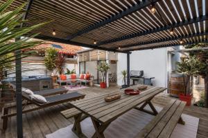 a patio with a wooden bench and a table at Villa NOVA in Capbreton