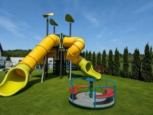 a playground with a slide in a park at Domki i Pokoje Baltimor in Grzybowo