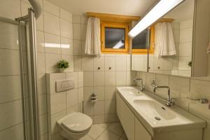 a bathroom with a sink and a toilet and a mirror at Haus Belvédère in Arosa +3 photos