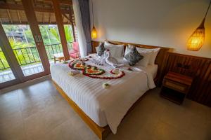 a bedroom with a large bed with decorations on it at The Dura Ubud in Ubud