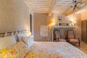 a bedroom with a bed and two chairs at Ma Maison De Loin - Luberon in Apt