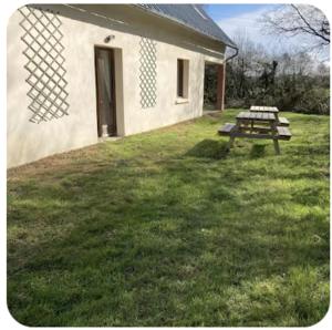 a building with a picnic table in the grass at Gite Rando Marquenterre in Rue