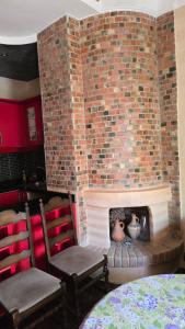 a brick fireplace with two chairs and vases in it at Appement in Agadir nʼ Aït Sa