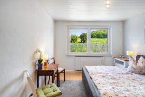 a bedroom with a bed and a desk and a window at Ferienwohnung am Herreder Wald in Nordhausen