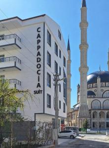 a building with a mosque next to a mosque at Cappadocia Suit Rezidans in Nevşehir