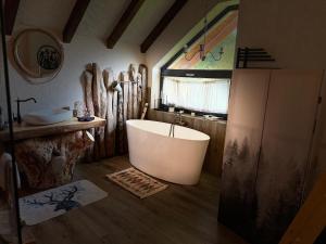 a bathroom with a bath tub and a sink at Cuibul Braneanului in Bran +63 photos