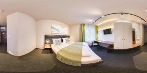 a hotel room with a large bed and a desk at JOESEPP´S HOTEL am Hallhof in Memmingen