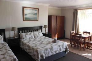 a bedroom with a bed and a table with a dining room at Petronella Guest House in Bethlehem