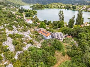 an aerial view of a house on a hill next to a lake at Apartment & Rooms - Marina in Ploče