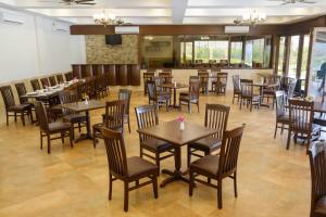 a restaurant with tables and chairs and a bar at Summer Vines - Nashik in Pandhurli