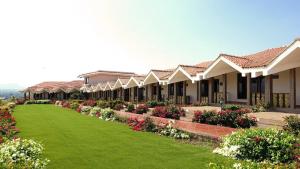 a row of houses with green grass and flowers at Summer Vines - Nashik in Pandhurli