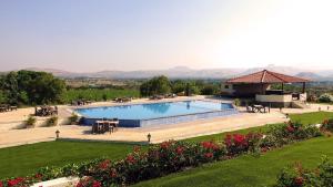 a large swimming pool in a garden with a gazebo at Summer Vines - Nashik in Pandhurli