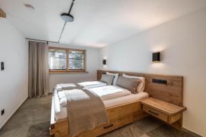 a bedroom with a wooden bed and a window at Appartementhaus Moritz in Reith bei Seefeld +46 photos