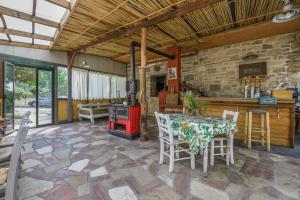 a patio with a table and chairs and a stove at Akros Oreon, Omalos Studio in Káto Sími