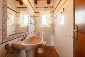a bathroom with a sink and a toilet and a mirror at Casa Sorrapa in Deltebre +24 photos