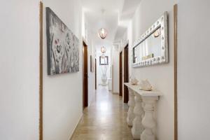 a hallway with white walls and a long hallway with paintings at Demetra Malophoros in Marinella di Selinunte +63 photos