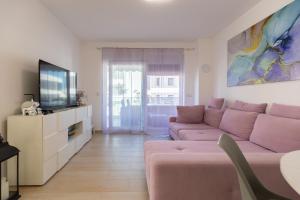 a living room with a couch and a tv at Enamare mit Terrasse in Šimuni