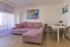 a living room with a purple couch and a table at Enamare mit Terrasse in Šimuni +12 photos