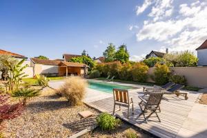 a backyard with a wooden deck and a swimming pool at Au Pressoir de Boisy in Pouilly-les-Nonains