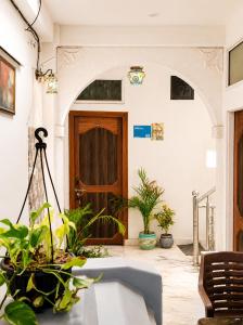 a room with plants and a wooden door at Ali Baba Hostel & Homestay in Jaipur