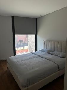 a bedroom with a large bed with a large window at Premium T1 - Blue Ocean in Espinho