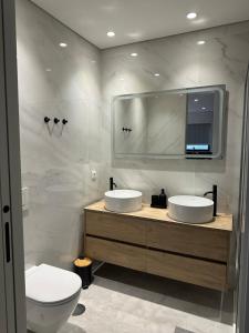 a bathroom with two sinks and a toilet at Premium T1 - Blue Ocean in Espinho