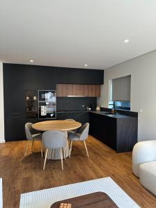 a kitchen and dining room with a table and chairs at Premium T1 - Blue Ocean in Espinho +11 photos