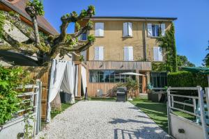 a house with a tree in the yard at Maison du Bonheur, Gîtes in Le Pin