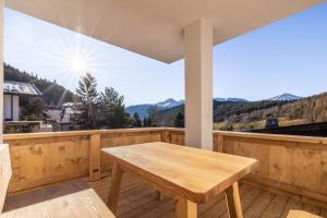 a wooden porch with a wooden table on a deck at Appartementhaus Moritz in Reith bei Seefeld