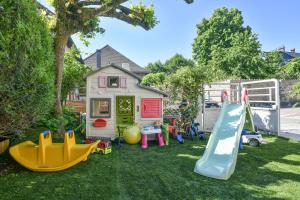 a yard with playground equipment in front of a house at Maison du Bonheur, Gîtes in Le Pin