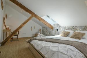 a bedroom with a large bed in a attic at Maison du Bonheur, Gîtes in Le Pin