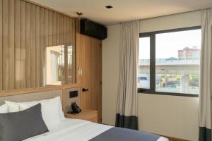 a bedroom with a bed and a large window at Punto Suites Periférico Sur in Mexico City
