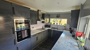a kitchen with gray cabinets and a stove top oven at Entire 3 bed house in Gloucester in Gloucester