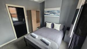 a small bedroom with a bed and a bench at Entire 3 bed house in Gloucester in Gloucester
