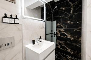 a bathroom with a white sink and a mirror at Occo by the Pool in Popeşti-Leordeni