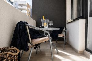 a small table and chairs on a balcony at Occo by the Pool in Popeşti-Leordeni