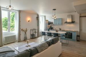 a living room with a couch and a kitchen at Maison du Bonheur, Gîtes in Le Pin