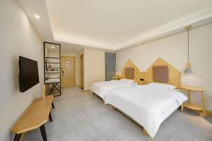 a hotel room with two beds and a television at Jianshanxi Designer Hotel in Mount Siguniang +8 photos