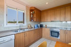 a kitchen with wooden cabinets and a sink and a window at Villa Santa Susanna 18 in Santa Susanna