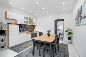 a kitchen and dining room with a wooden table and chairs at Apartment & Rooms - Marina in Ploče