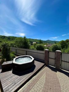 a hot tub sitting on a wooden deck at N V New View in Yaremche