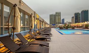a row of chairs with umbrellas next to a pool at Incheon Songdo Stay31 in Incheon