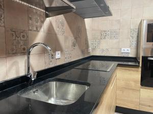 a kitchen with a stainless steel sink in a kitchen at Casa Los Tres Panetes Béjar in Béjar +11 photos