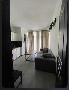 a living room with a couch and a table at GONIO Mgzavrebi III Apartment 403 in Gonio