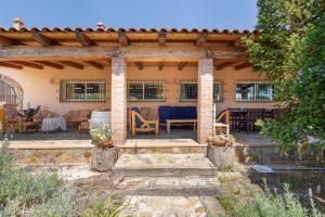 a house with a patio with chairs and tables at Villa Santa Susanna 18 in Santa Susanna