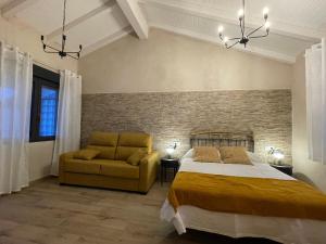 a bedroom with a bed and a couch at Casa Los Tres Panetes Béjar in Béjar