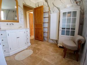 a bathroom with a white cabinet and a mirror at Les Volets Verts-Dordogne in Plazac