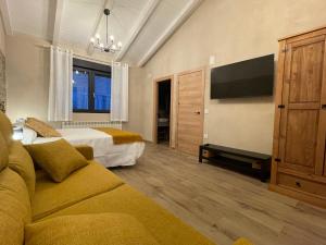 a hotel room with two beds and a couch at Casa Los Tres Panetes Béjar in Béjar
