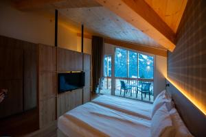 a bedroom with a bed and a large window at mySHH Smart in Vigo di Fassa