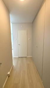 an empty room with a white door and a wooden floor at City Studio Kalliossa in Helsinki